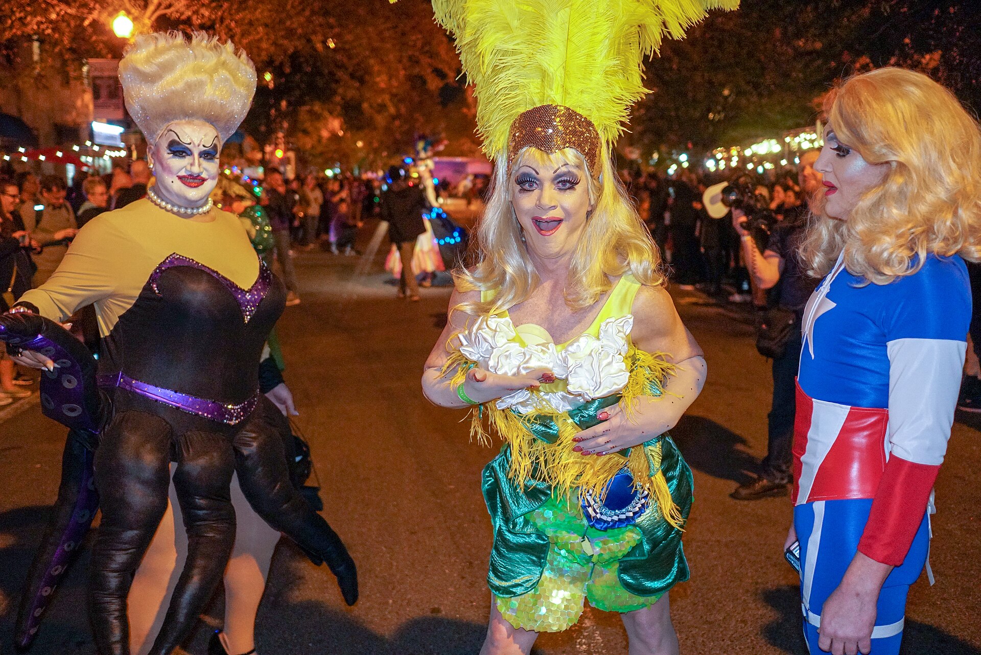 Drag queens in feathered and sequinned costumes on 17th Street NW at night during DC's annual High Heel Race